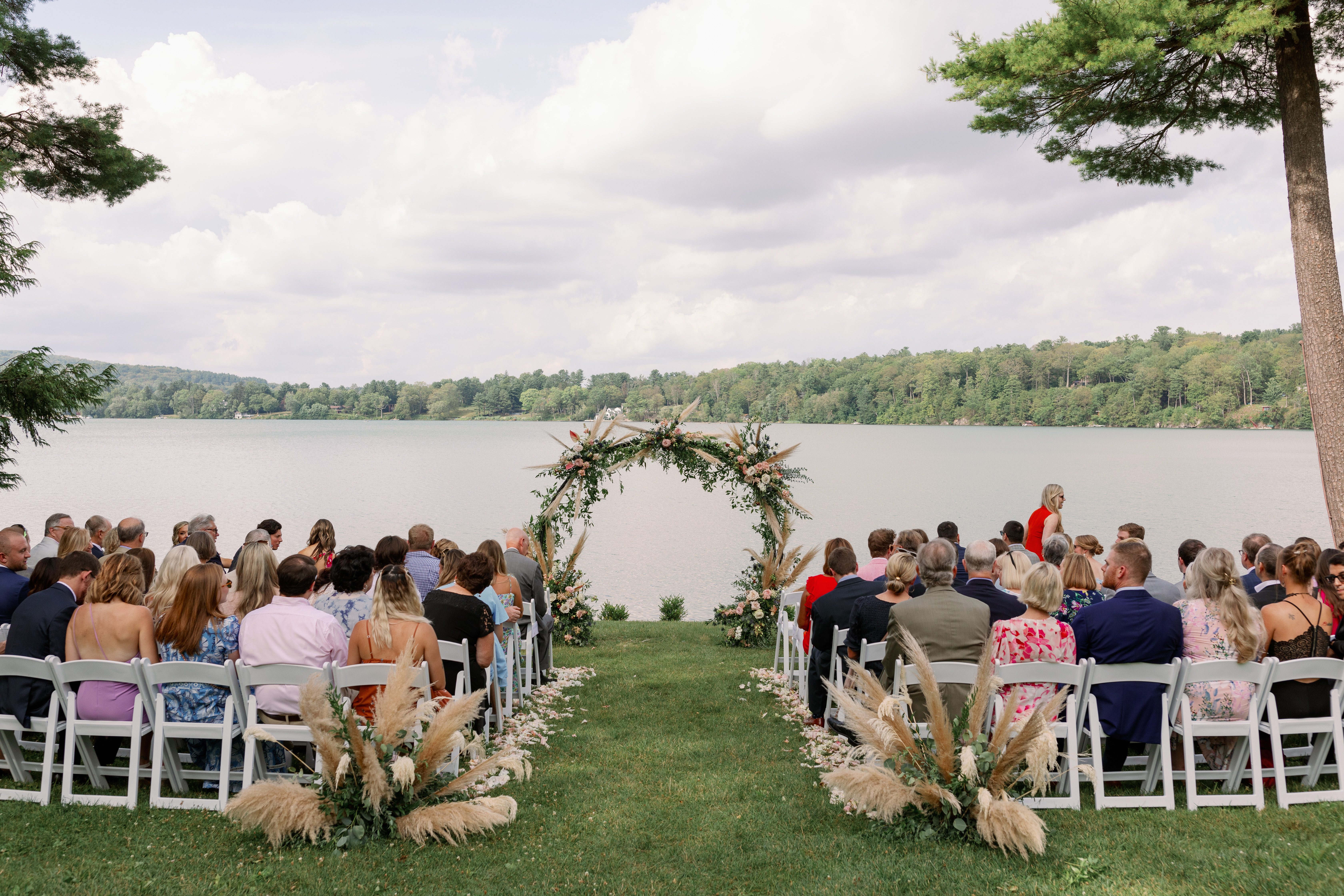 wedding setup with floral arch and guests seated